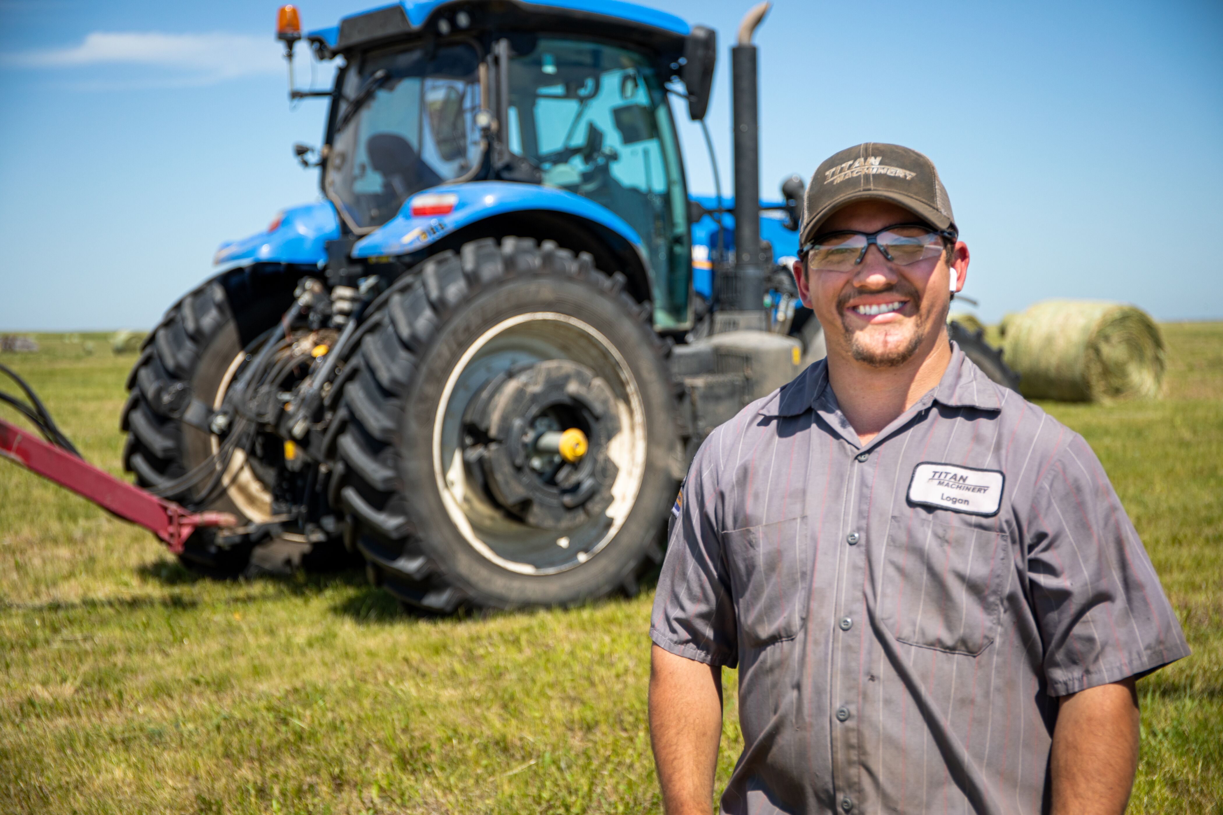 Titan Machinery Service Technician In Front Of New Holland Tractor