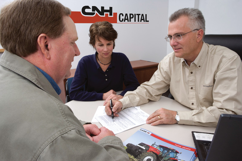 Customer signing equipment insurance plan with CNH Capital logo in background