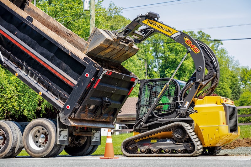 Construction_Bottom Image New Holland Construction C245 skid steer dumping into truck