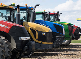 Case IH, CAT, New Holland, and John Deere tractors lined up