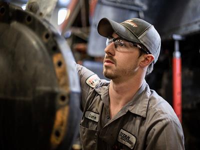 Service Technician working on Case IH equipment with a grinder