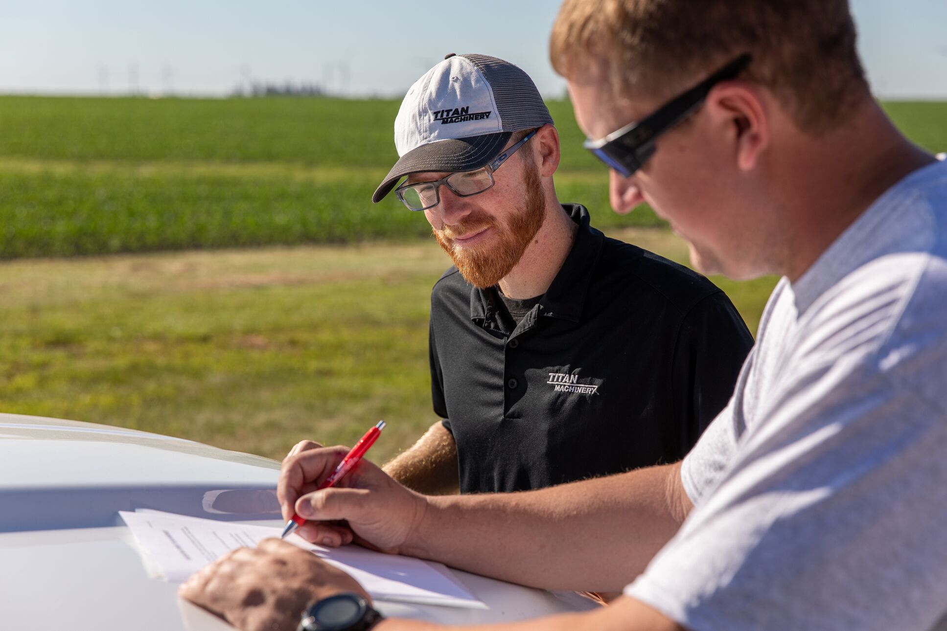 Titan Machinery Salesman with customer Titan Machinery Salesman with customer signing contract